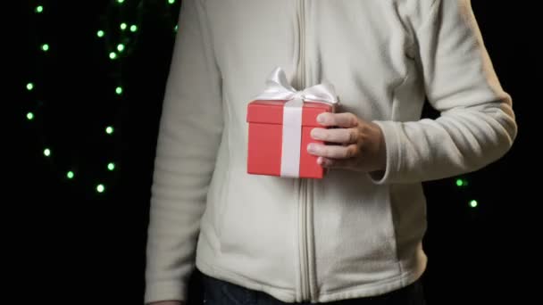 childs mano dando caja roja con cinta blanca. navidad, concepto de año nuevo - Imágenes, Vídeo