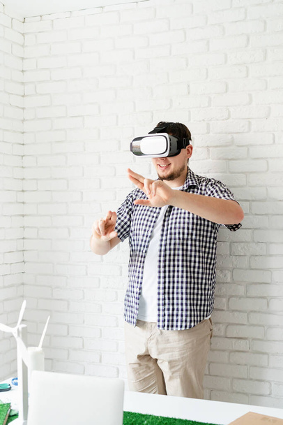 VR szemüveget használó mérnök vagy tervező a megújuló energiával kapcsolatos projekt vizualizációjával - Fotó, kép
