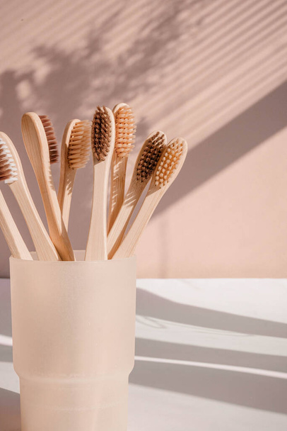 Cepillo de dientes de bambú de cero residuos sobre fondo pastel con tonos florales. Foto de alta calidad - Foto, imagen