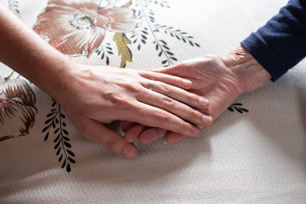 Hand of a man holding the hand of his grandmother - Foto, imagen
