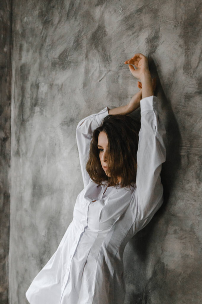 Красивая кудрявая девушка позирует в белой рубашке - Фото, изображение