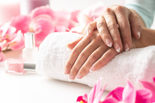 Relaxed hands of a woman placed on a towel awaiting her manicure to be done and nail polish applied. - Foto, afbeelding