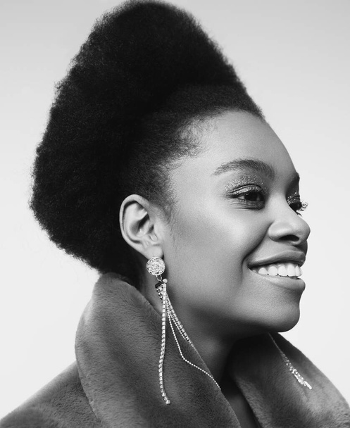 Classic black and white portrait of a beautiful girl with clean skin, smile and accessories - Fotó, kép