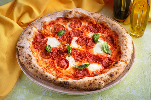 Pepperoni Pizza with Mozzarella cheese, salami, Tomatoes, pepper, Spices and Fresh Basil. Italian pizza - Foto, Bild