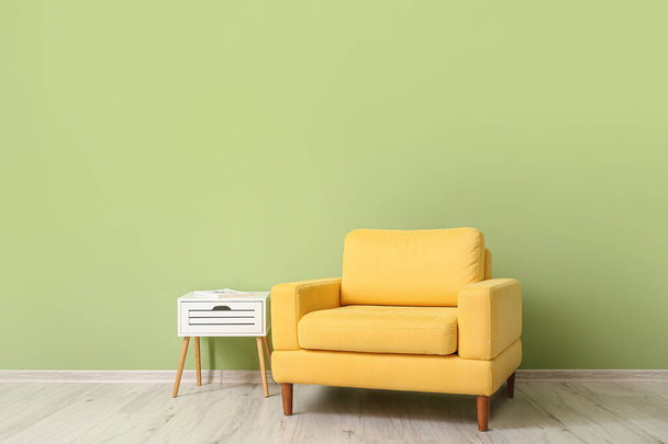 Nojatuoli pöytä lähellä väriä seinään huoneessa - Valokuva, kuva