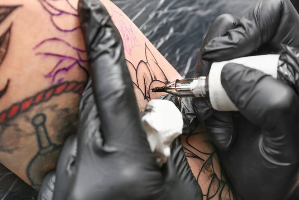 Artista professionista che fa tatuaggi nel salone - Foto, immagini