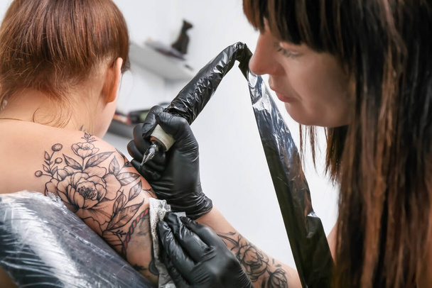 Professional artist making tattoo in salon - Photo, Image