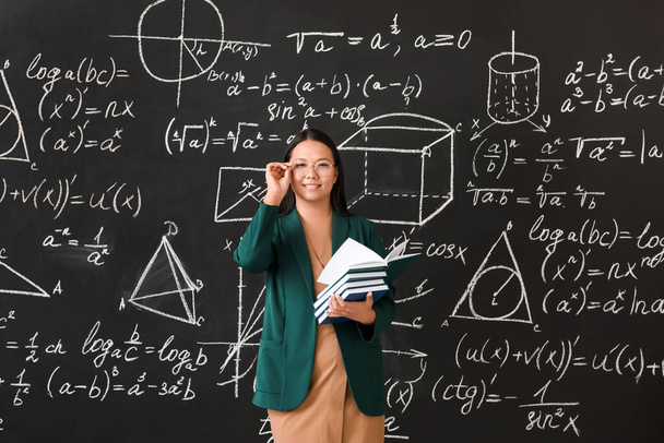 Asian female teacher near blackboard in classroom - Photo, Image