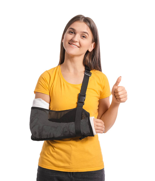 Young woman with broken arm on white background - Photo, Image