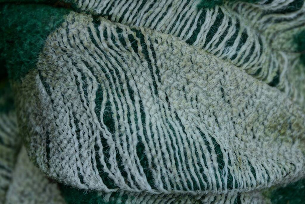 fondo de tela gris de un pedazo de materia verde desgarrada en la ropa - Foto, imagen