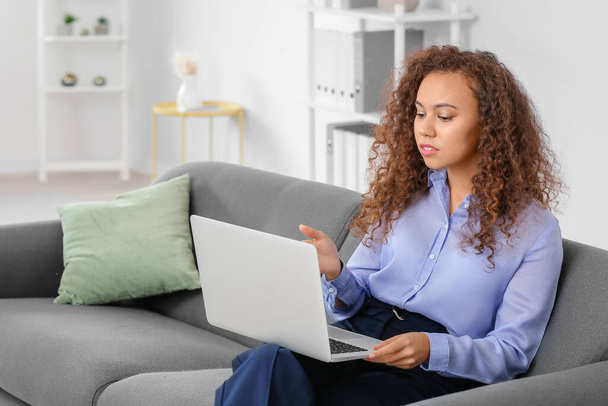 Портрет женщины-афроамериканского психолога с ноутбуком в офисе - Фото, изображение