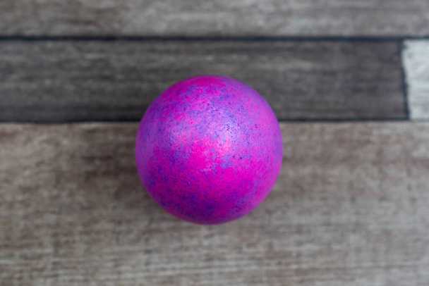Huevo de Pascua de color sobre fondo de madera, vista superior - Foto, Imagen