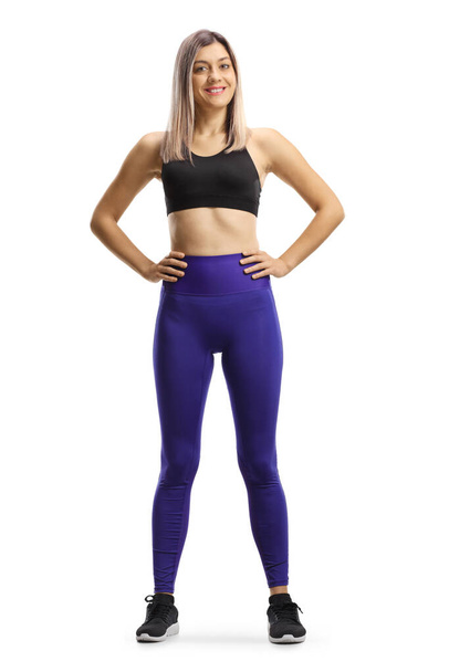 Full length portrait of a young blond woman in leggings and short sporty top isolated on white background - Foto, Imagen