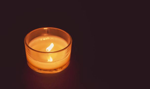 Brennende Kerze heiße Flamme im Kerzenständer aus Glas. - Foto, Bild