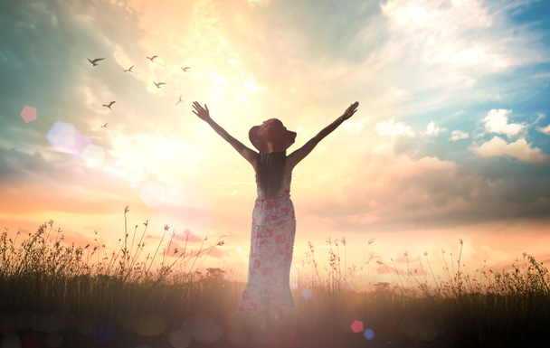 Praise and worship God concept: Silhouette of healthy woman raised hands for praise and worship God at autumn sunset meadow background - Photo, Image