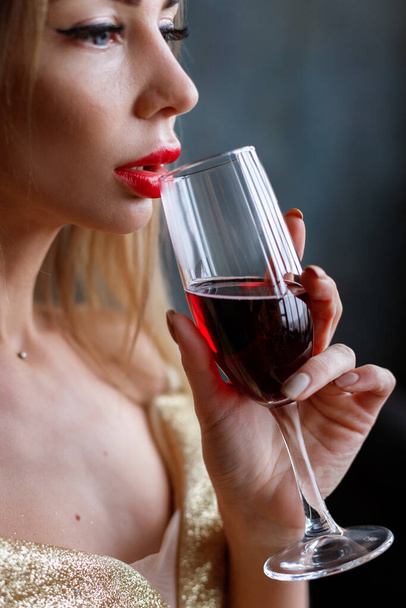 赤い唇をした女性の手の中のガラスは - 写真・画像