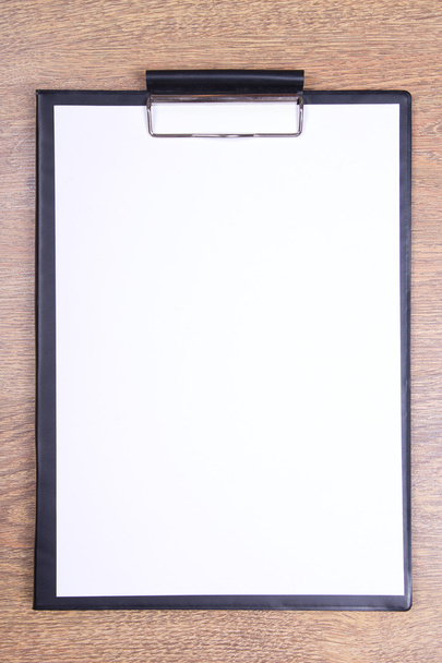 Klembord met blanco papier op houten tafel - Foto, afbeelding