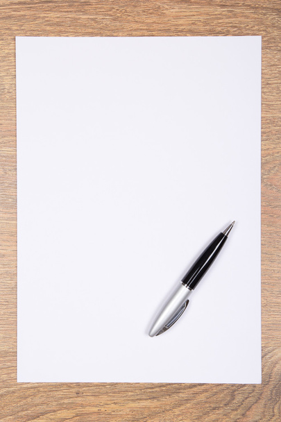 Hoja en blanco de papel y lápiz sobre mesa de madera
 - Foto, Imagen