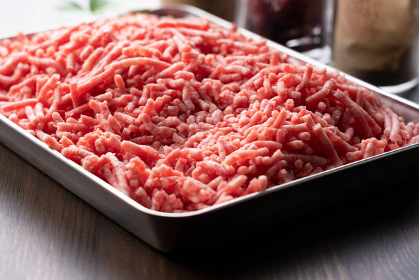 Κιμάς κρέας σε δίσκο σε ξύλινο φόντο. Εικόνα πριν το μαγείρεμα - Φωτογραφία, εικόνα