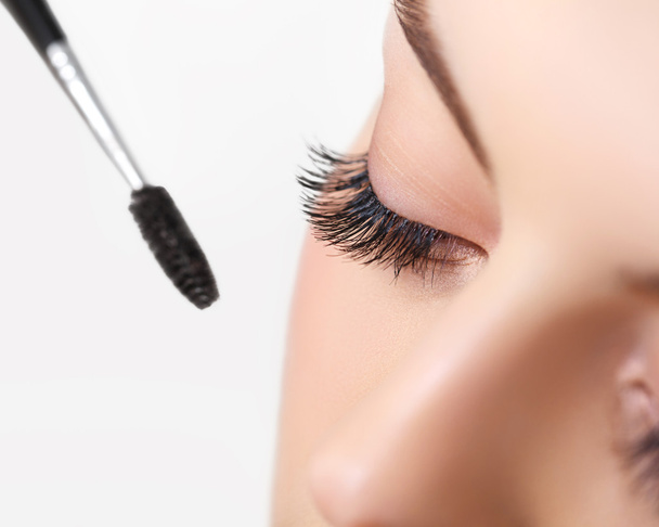 Beautiful woman applying mascara on eyelashes - Foto, Bild