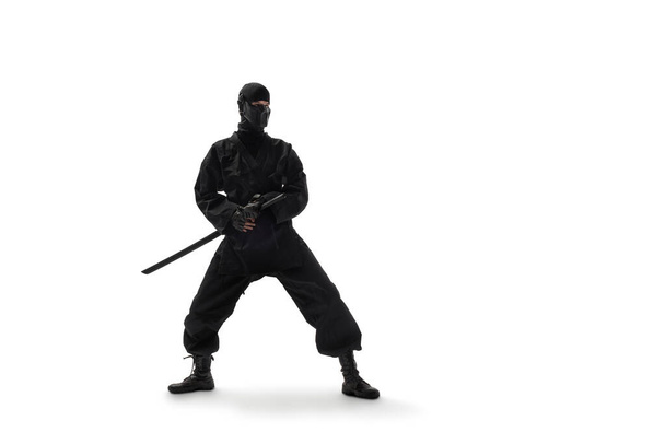 one japanese ninja in black uniform with katana sword, on white background, isolated - Fotó, kép