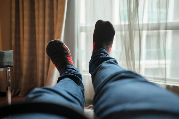 Selective focus of low section of man relaxing at the hotel room - Photo, Image