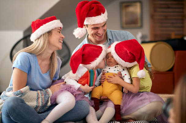 Happy parents spening Christmas time together with their kids at home - Foto, Imagem