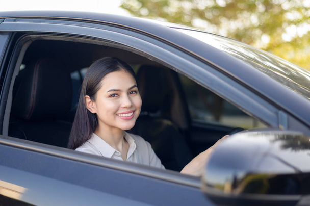 A beautiful young smiling woman driving her car, insurance and finance concept - Photo, image