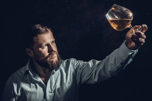 Solid bearded man in shirt with glass of whisky - Фото, зображення