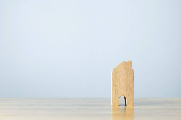Miniaturowy drewniany dom na drewnianym stole. Koncepcja inwestycji mieszkaniowych, hipotecznych i nieruchomości - Zdjęcie, obraz