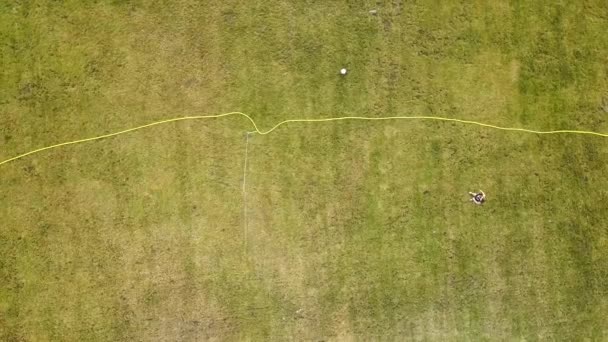 Vista aérea de arriba hacia abajo de la superficie del campo de fútbol cubierto con hierba verde y aspersores rociando agua. - Metraje, vídeo