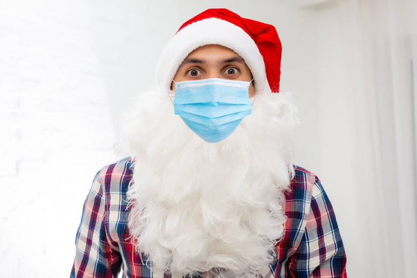 Illness and colds. santa claus in medical mask. red background. - Fotografie, Obrázek