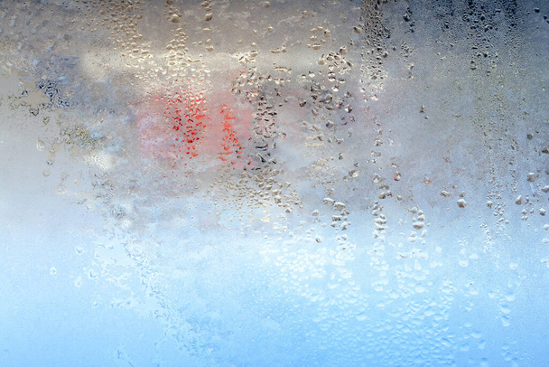La textura de las gotas congeladas de condensación en una ventana de vidrio transparente. Gotas de agua. Lluvia. Fondo de textura abstracta. Un fuerte chasquido frío, una gota de agua congelada en el vaso en invierno - Foto, Imagen