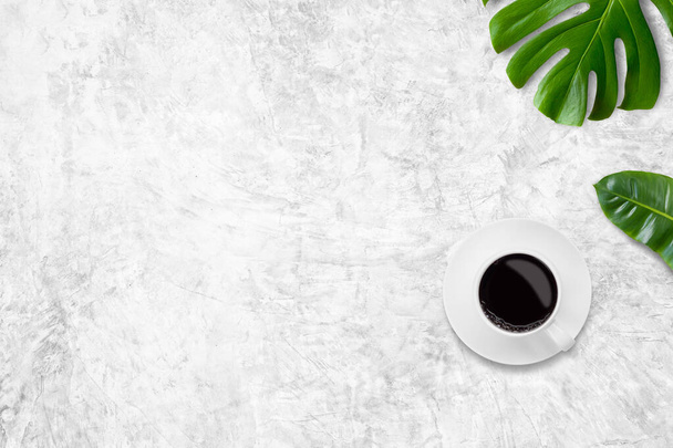 Cup of coffee and tropical leaves monstera on white background. top view, copy space, flat lay - Foto, Bild