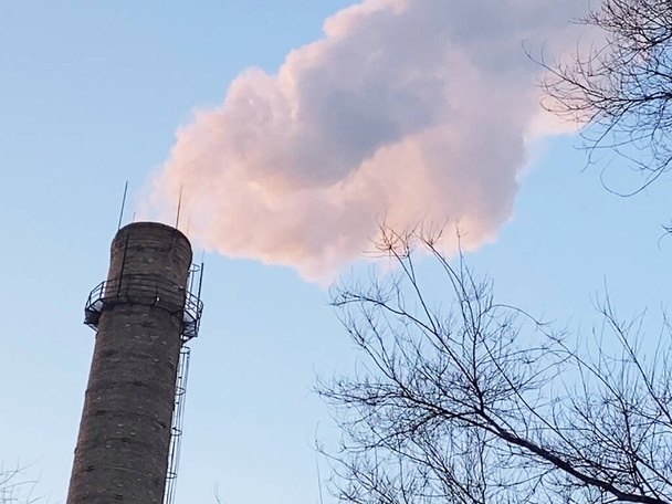 Установка труб с серым дымом на голубом небе, химический завод башни атомной электростанции против голубого неба - Фото, изображение