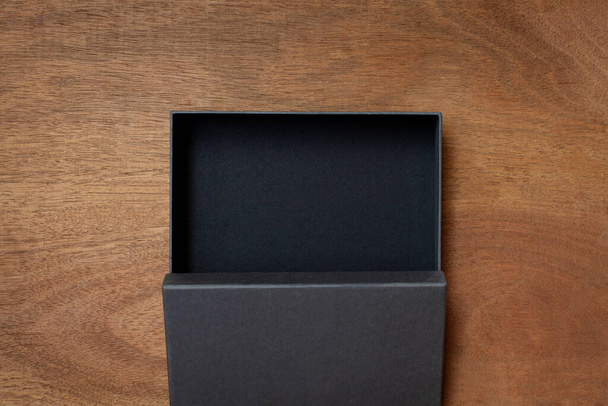 Чорна коробка для ремесел на дерев'яному столі
 - Фото, зображення