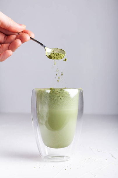 Matcha with milk in a glass on a light background - Foto, afbeelding