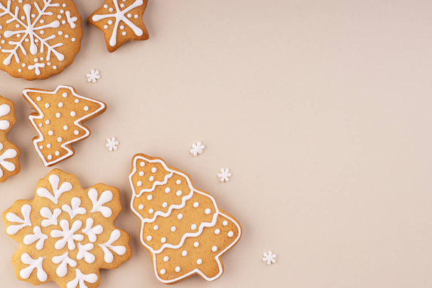 Christmas gingerbread on a soft pastel background with space for text. Snowflakes and Christmas trees are scattered on the table - Foto, Imagem