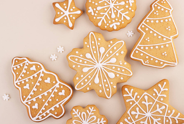 Christmas gingerbread on a soft pastel background with space for text. Snowflakes and Christmas trees are scattered on the table - Fotoğraf, Görsel