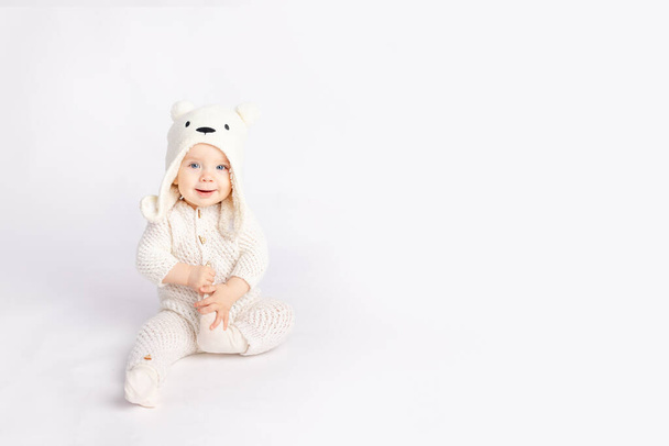 bebê em um terno quente e um chapéu de urso em um fundo isolado branco, espaço para texto - Foto, Imagem