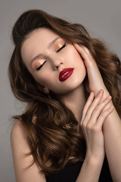 muotokuva viehättävä nainen aaltoileva tukka ja kulta korvakorut. Täydellinen meikki, punainen huulipuna - Valokuva, kuva
