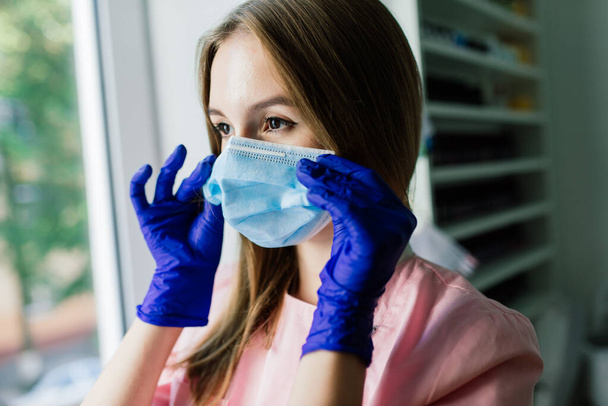 Beautiful female medical worker or manicure master in medical mask - Photo, Image