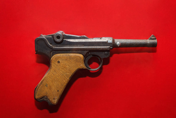 Γερμανικό παλιό πιστόλι απομονωμένο σε κόκκινο φόντο - Φωτογραφία, εικόνα