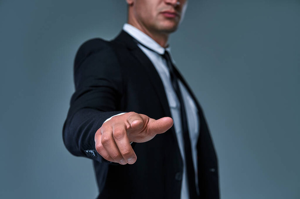 Business man with pointing to something or touching a touch screen on gray background. - Φωτογραφία, εικόνα