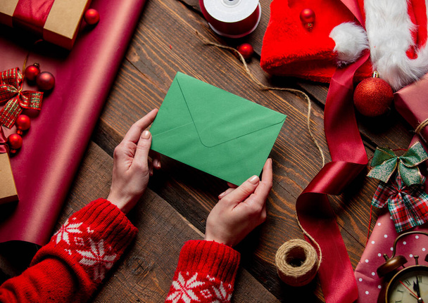 Woman hold mail in envelope on wooden table in wrapping time - Photo, image