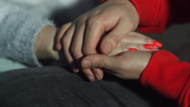 Mann streichelt eine Frauenhand, hautnah, kümmert sich um einen geliebten Menschen - Filmmaterial, Video