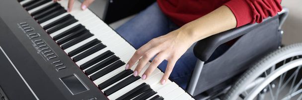Frau im Rollstuhl spielt Synthesizer Finger liegen auf Tasten - Foto, Bild