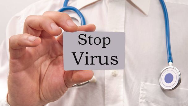 stop virus text on a business card in the doctors hand. - Zdjęcie, obraz