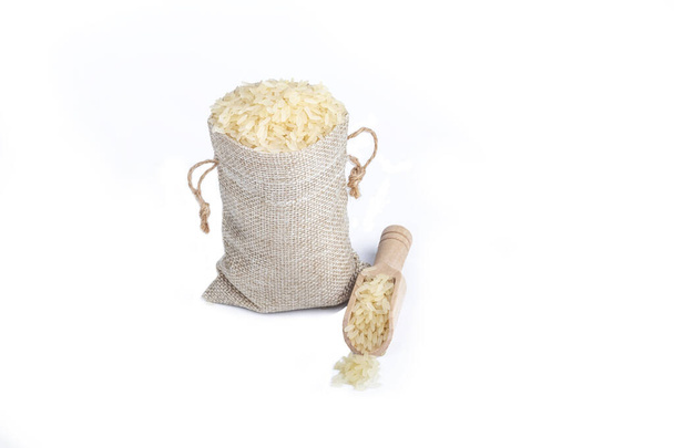 Studio lighting. on a white background. Not a big bag of rice. Wooden spice spoon nearby. No isolation. - Foto, Imagem