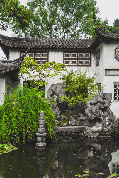Architecture traditionnelle chinoise au bord de l'étang dans la zone scénique du jardin persistant à Suzhou, Jiangsu, Chine - Photo, image